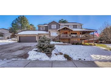 Two-story home with a large deck, attached garage, and landscaping at 6215 Northwoods Glen Dr, Parker, CO 80134