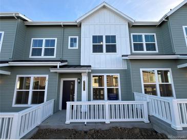 Modern two-story townhome with white trim and gray siding, welcoming front porch at 14585 W 91St Dr # C, Arvada, CO 80005