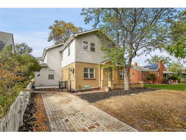 Two-story home with brick and stucco exterior, paved driveway at 1431 Tamarac St, Denver, CO 80220