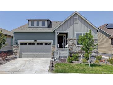 Two-story craftsman style home with gray siding, stone accents, and a two-car garage at 8901 S Ukraine Ct, Aurora, CO 80016