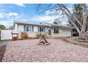 Ranch style home with a rock front yard and mature trees at 6563 Simms St, Arvada, CO 80004