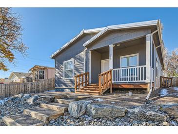 Gray house with wooden stairs and porch at 149 Poplar St, Lochbuie, CO 80603