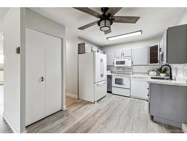 Modern kitchen with gray cabinets and white appliances at 9315 E Center Ave # 11A, Denver, CO 80247