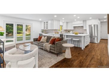 Open kitchen with island, white cabinets, and stainless steel appliances at 545 S Harrison Ln, Denver, CO 80209