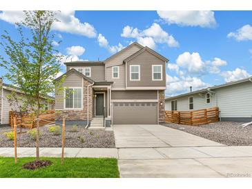 Two-story house with gray siding, a two-car garage, and landscaping at 9374 Bahama Ct, Commerce City, CO 80022