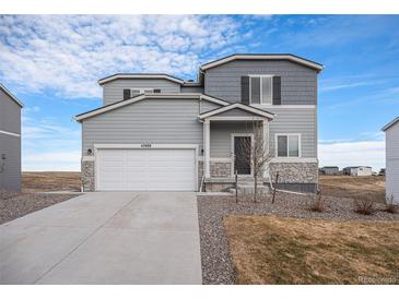 Two-story house with gray siding, white garage door, and landscaping at 42888 Ivydel St, Elizabeth, CO 80107