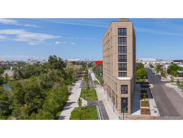 Modern multi-story building with river views and nearby green space at 3575 Chestnut Pl # 606, Denver, CO 80216