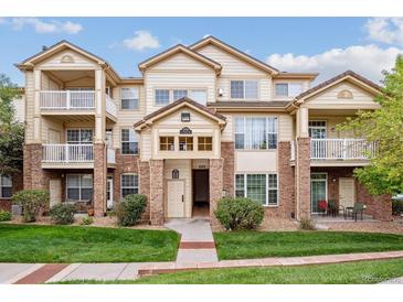 Beige three-story condo building with balconies and landscaping at 5703 N Gibralter Way # 204, Aurora, CO 80019