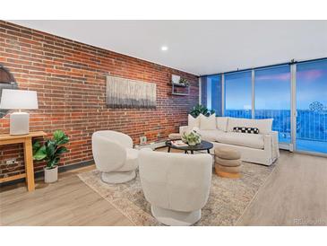 Spacious living room features a brick accent wall, comfortable seating, and large windows at 955 Eudora St # 1008, Denver, CO 80220