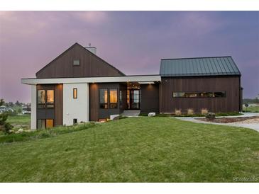 Modern farmhouse exterior boasts a metal roof and dark wood siding at 11229 Running Kit Pl, Franktown, CO 80116