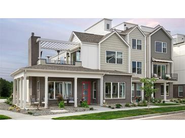 Two-story modern home with brick exterior, covered porch, and rooftop deck at 888 S Valentia St # 106, Denver, CO 80247