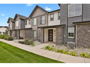 Row of townhomes, showcasing landscaping and walkway at 19733 W 93Rd Ln # D, Arvada, CO 80007