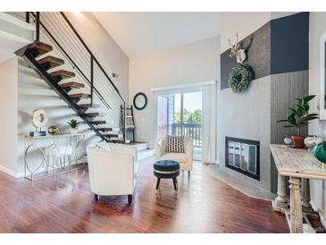 Bright living room with hardwood floors, fireplace, and modern furnishings at 10785 W 63Rd Pl # 307, Arvada, CO 80004
