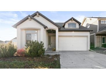 White ranch-style house with a two-car garage and landscaping at 5535 Danube St, Denver, CO 80249