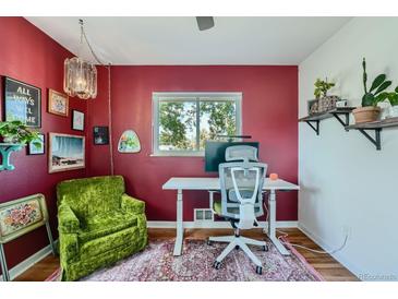 Bright home office features a red accent wall, comfortable seating, and a workspace at 13194 W 23Rd Ave, Golden, CO 80401