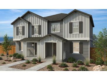 Two-story home with gray siding, multiple windows, and a landscaped front yard at 659 N Bently St, Watkins, CO 80137