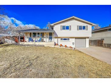 Ranch style home with gray exterior, landscaping, and attached garage at 765 E Panama Dr, Centennial, CO 80121