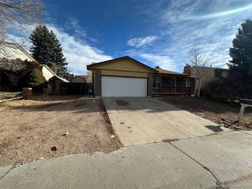 Ranch style home with a two-car garage and mature landscaping at 2084 S Rifle St, Aurora, CO 80013