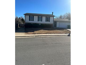 Ranch-style house with attached garage and a yard at 17898 E Mexico Dr, Aurora, CO 80017