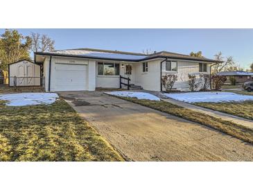 Ranch style home with white brick exterior, attached garage, and landscaping at 3390 W 92Nd Pl, Westminster, CO 80031