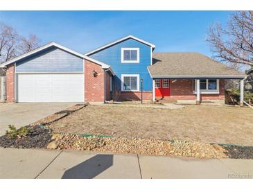 Brick and blue-sided two-story house with attached garage and landscaping at 18365 E Mansfield Ave, Aurora, CO 80013