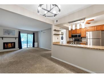 Open concept kitchen and living room with fireplace and patio access at 539 Wright St # 208, Lakewood, CO 80228