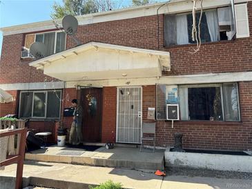 Brick duplex with a front porch and landscaping at 1125 S Raritan St, Denver, CO 80223