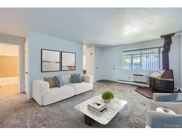 Bright living room features a fireplace and is furnished with a sofa and coffee table at 2565 S Sheridan Blvd # 20, Denver, CO 80227