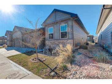 Gray exterior of charming ranch home with landscaping and two-car garage at 11874 Barrentine Loop, Parker, CO 80138