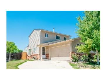 Beige two-story house with attached garage at 12581 Elm St, Thornton, CO 80241