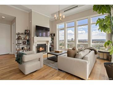 Living room with hardwood floors, fireplace, and large windows offering city views at 7600 Landmark Way # 1403, Greenwood Village, CO 80111