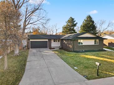 Ranch style home with a brick facade, attached garage, and well-maintained lawn at 2189 S Field Way, Lakewood, CO 80227