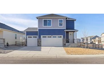 Two-story house with blue and gray siding, two-car garage, and landscaped yard at 109 Racer St, Bennett, CO 80102