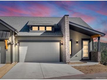 Modern exterior of a townhouse with a gray stone facade and a two-car garage at 3907 Piney Grove St, Evergreen, CO 80439