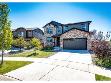 Two-story house with stone and siding, two-car garage, and landscaped yard at 25026 E Bayaud Pl, Aurora, CO 80018