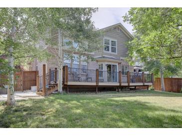 Spacious backyard with a large deck and mature trees at 2599 S Jebel Way, Aurora, CO 80013