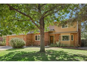 Two-story home with brick and siding exterior, and a landscaped yard at 1058 W Choke Cherry Dr, Louisville, CO 80027