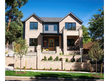 Two story brick home with a welcoming front porch and landscaped yard at 428 S Williams St, Denver, CO 80209