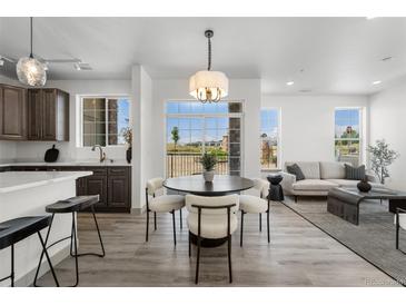 Modern dining area with a round table and chairs, open to the kitchen at 18633 Stroh Rd # 1-106, Parker, CO 80134