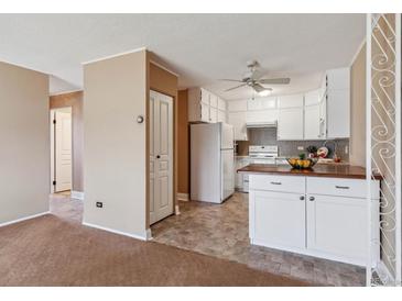 Bright eat-in kitchen with white cabinets and wood countertops at 690 S Alton Way # 1C, Denver, CO 80247