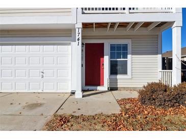 Two-story house with attached garage and red front door at 1741 Zephyr St, Brighton, CO 80603