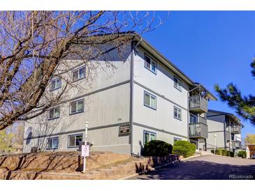 Exterior view of a three-story apartment building with balconies and landscaping at 7525 W 62Nd Ave # 11, Arvada, CO 80003