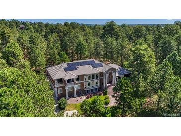 Luxury home with solar panels and a tree-filled lot at 17075 Viscount Ct, Monument, CO 80132