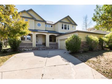 Two-story yellow house with a large front yard at 22264 E Frost Pl, Aurora, CO 80016