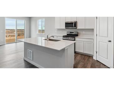 Modern kitchen with island, stainless steel appliances, and white cabinets at 5909 Red Barn Ave, Mead, CO 80504