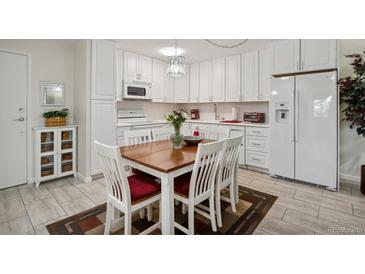 Bright kitchen with white cabinets and a dining area at 9340 E Center Ave # 2C, Denver, CO 80247