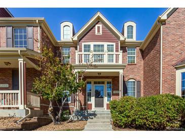 Brick two-story home with balcony and landscaping at 14215 W 84Th Pl, Arvada, CO 80005