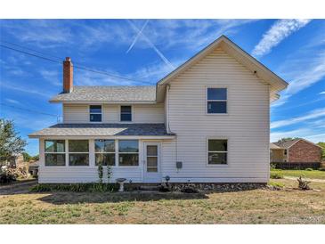 White farmhouse with a sunroom at 4550 Miller St, Wheat Ridge, CO 80033