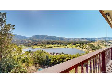 Deck overlooking a lake and mountain range at 6301 Perry Park Blvd # 13, Larkspur, CO 80118