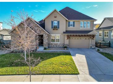Two-story house with stone accents, a large driveway, and a landscaped lawn at 14672 Melco Ave, Parker, CO 80134